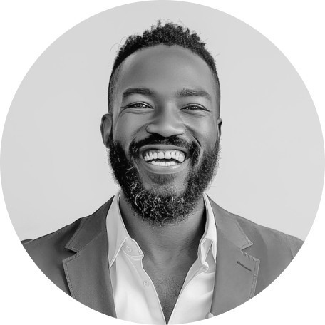 A smiling man with a beard, wearing a suit, against a light background.