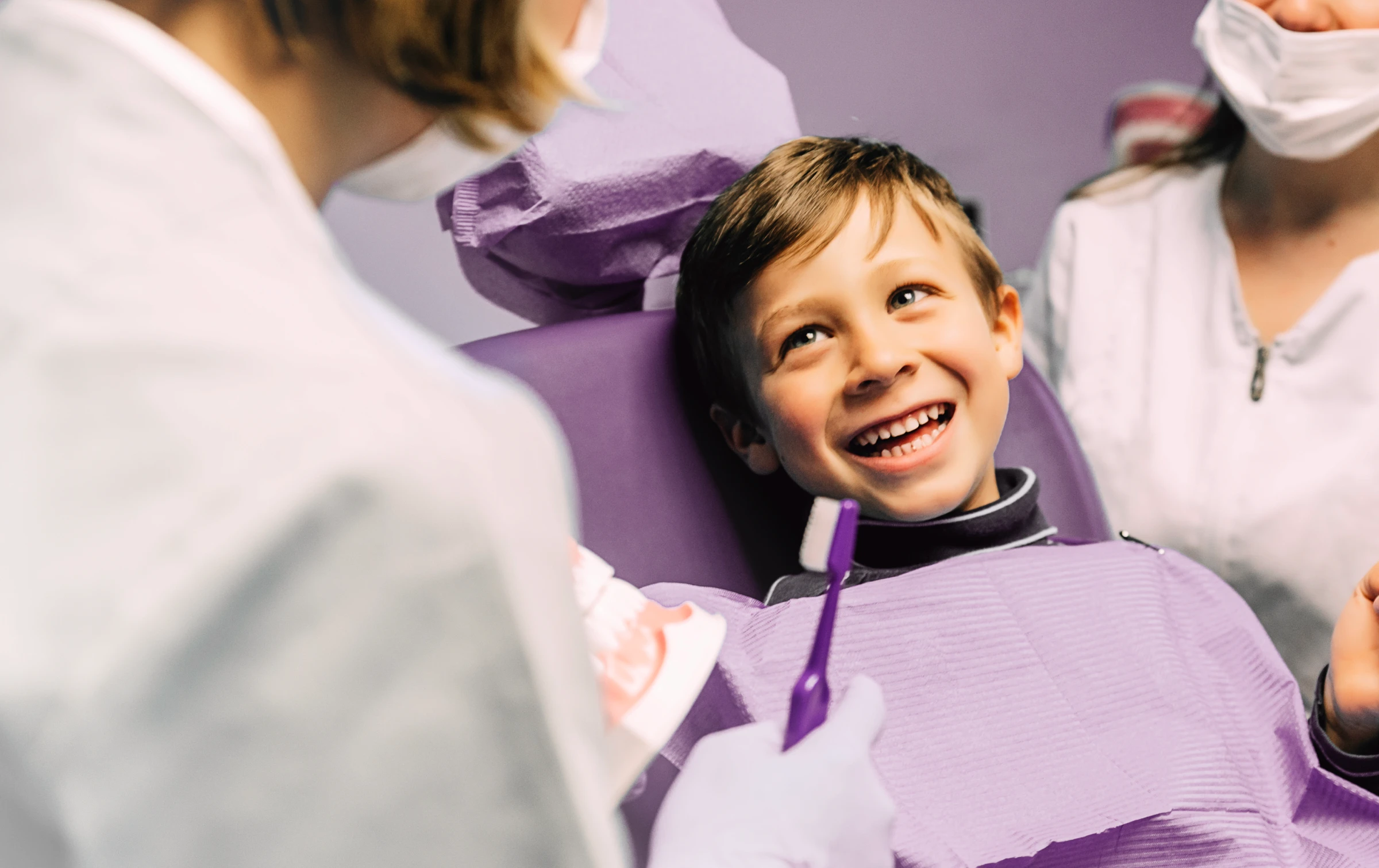 Kobieta z uśmiechem prezentująca efekty bondingu na swoich zębach.