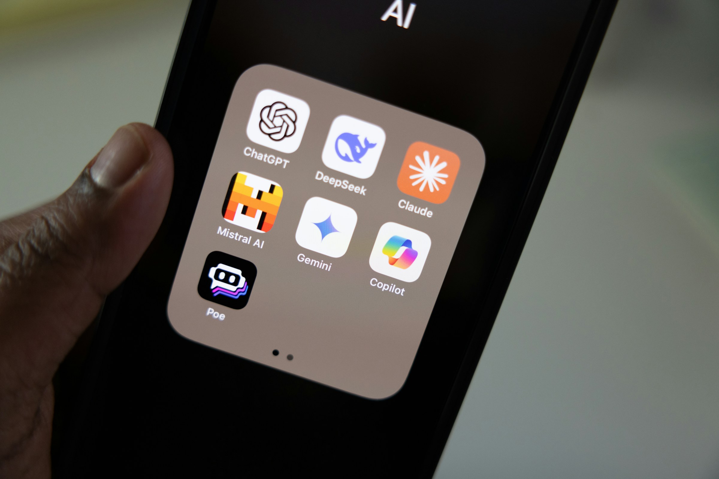 A phone showing different AI apps, including ChatGPT, Claude and Gemini