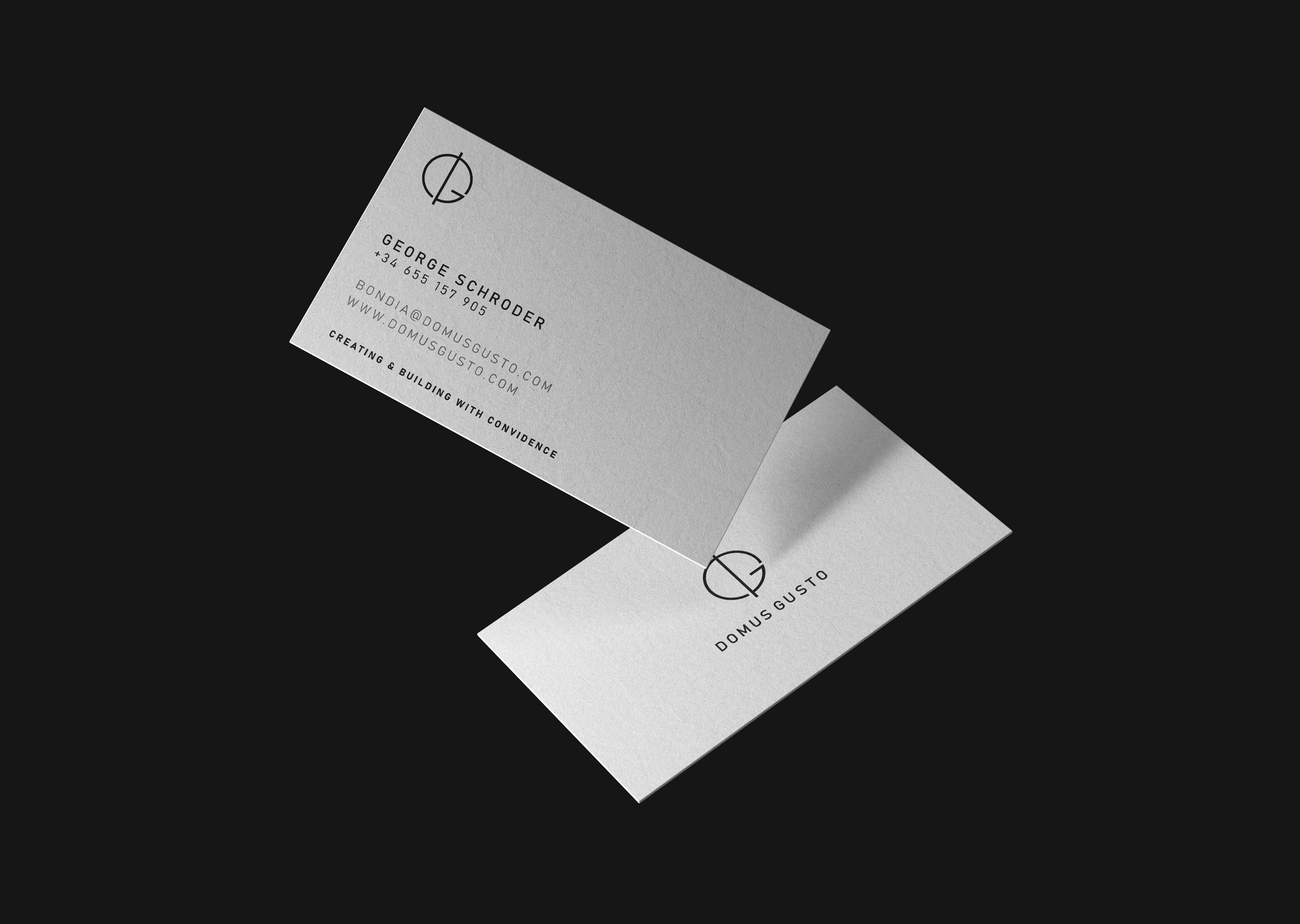 busniness cards in white with black print against a black background of Domus Gusto Properties