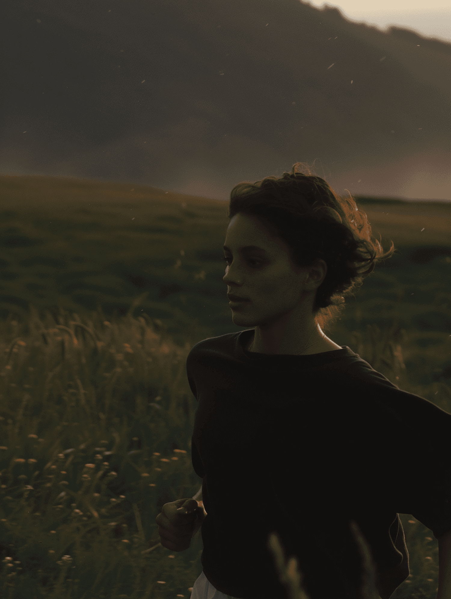 Person jogging through tall grass with mountains in background