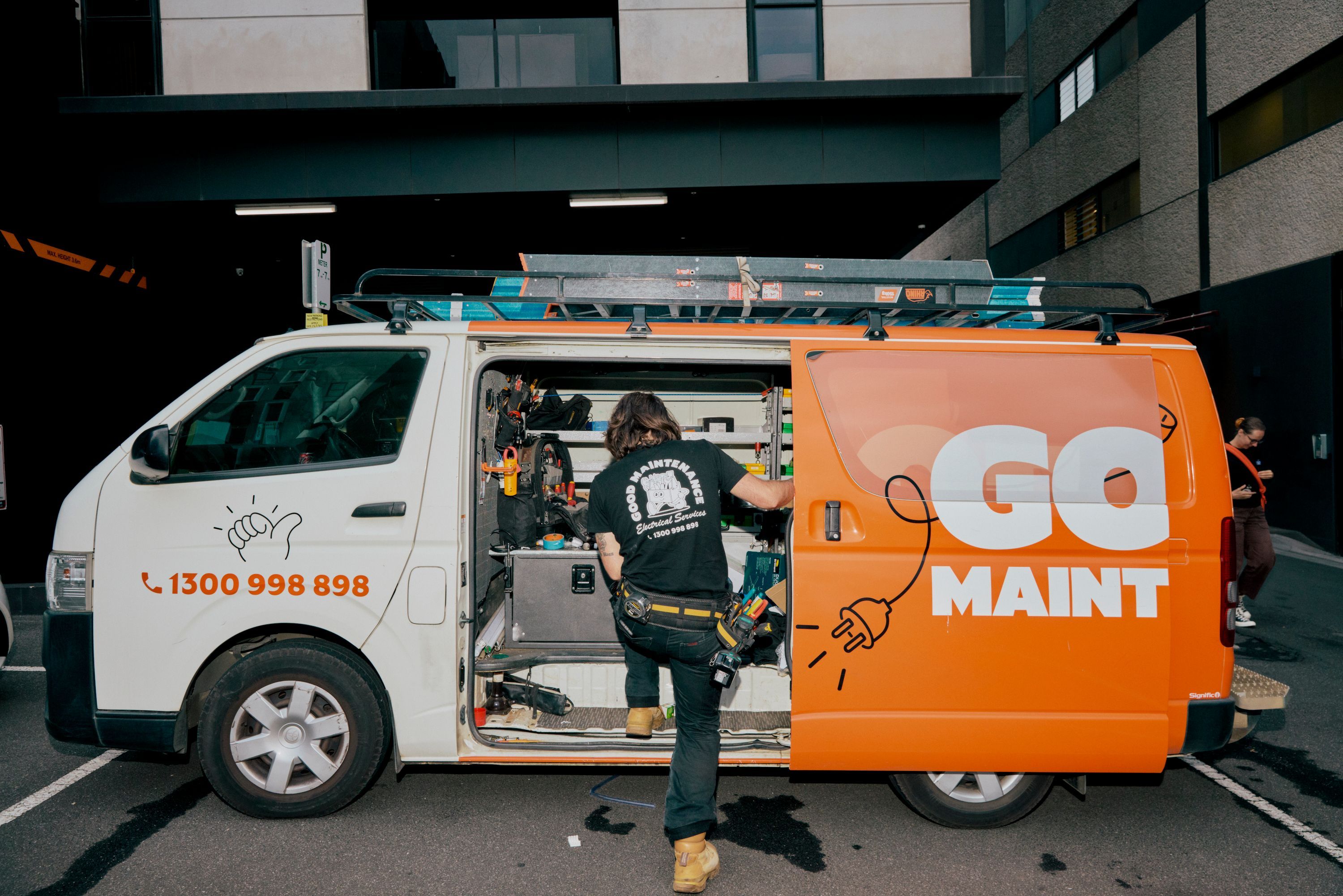 Good Maintenance electrician wearing branded shirt standing with tools, providing electrical services in Melbourne.