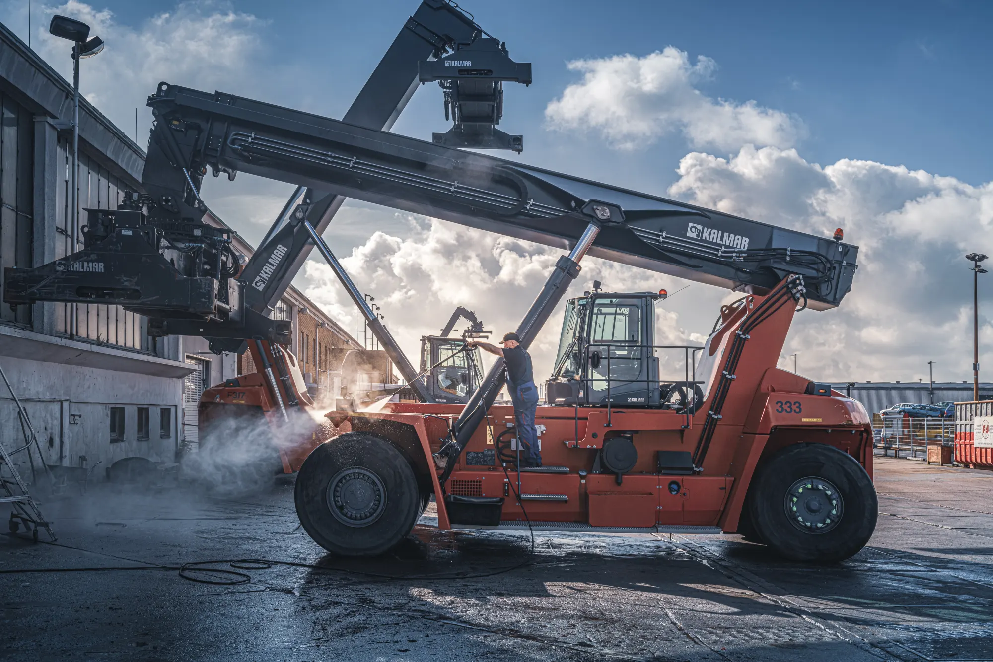 Flotte gewarteter Reachstacker am Hamburger Containerterminal im Sonnenuntergang