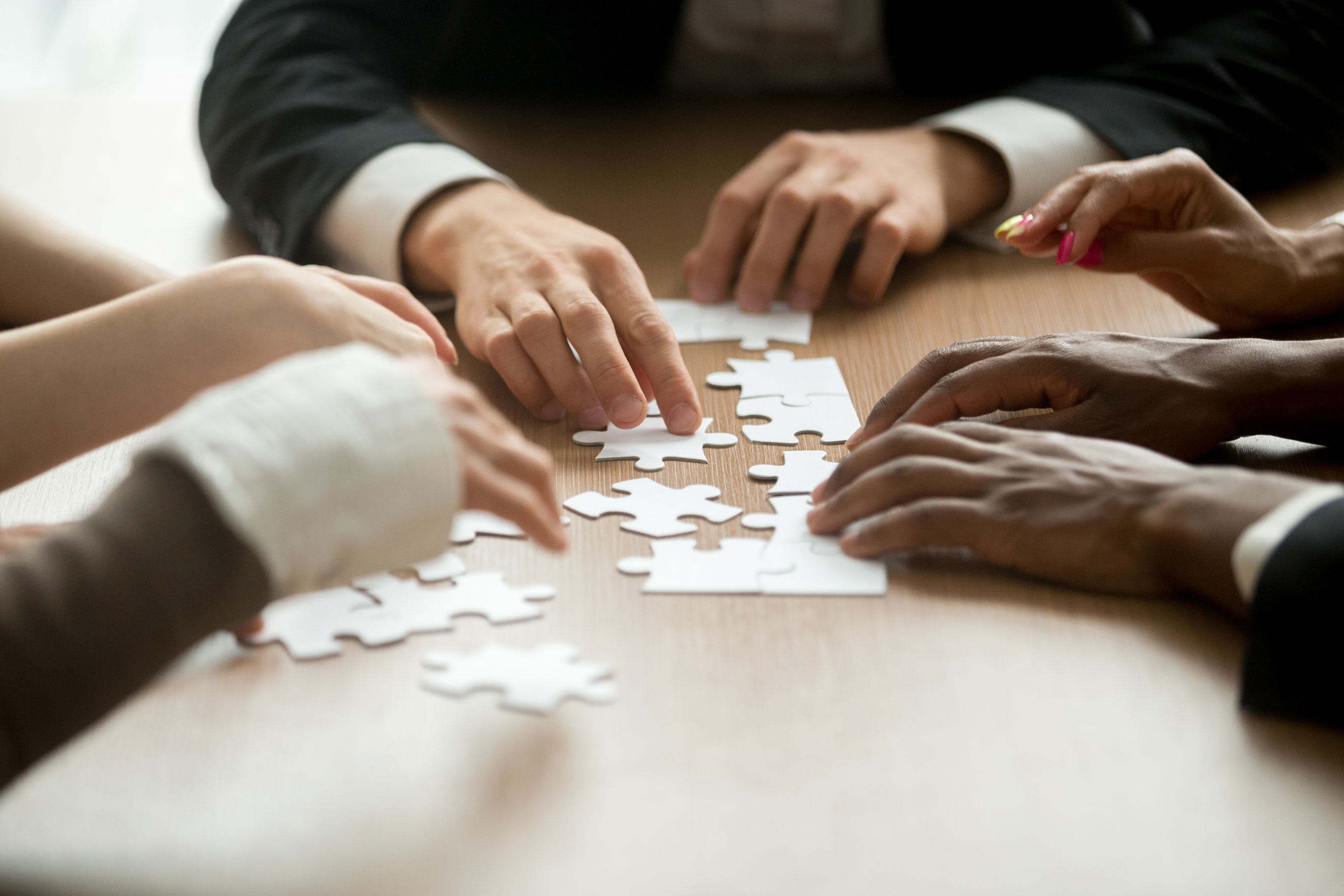 groupe-de-personnes-ajustant-ensemble-les-pièces-d’un-puzzle,-illustrant-l’apprentissage-par-l’essai