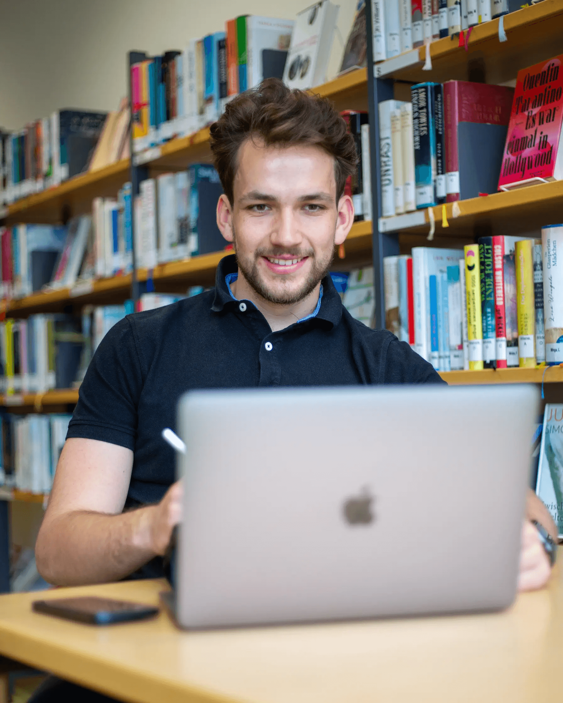 Niklas Freese lernt mit dem Laptop in der Bibliothek für den TMS und EMS