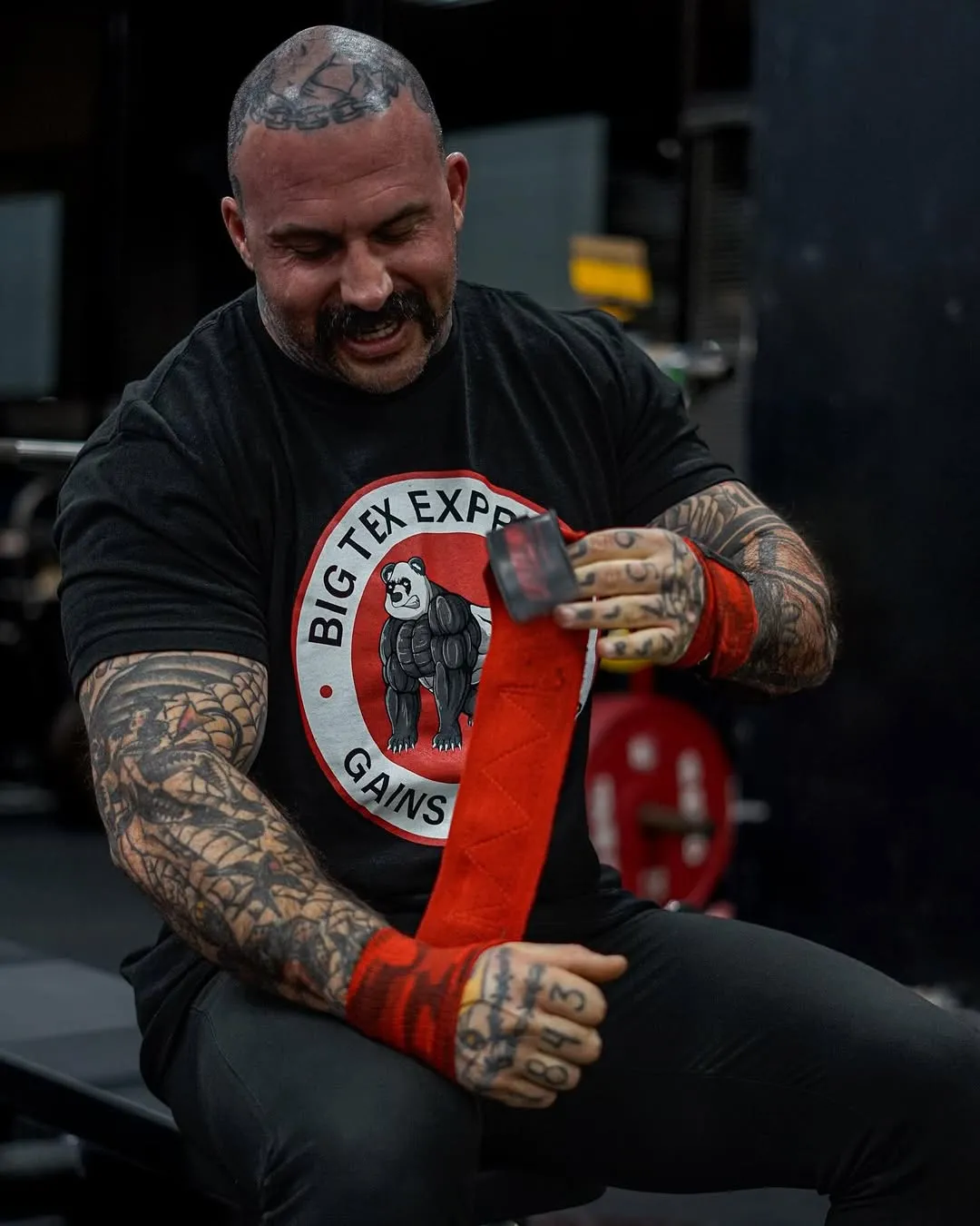 Powerlifter chalking hands with Big Tex Gym gear at a competition