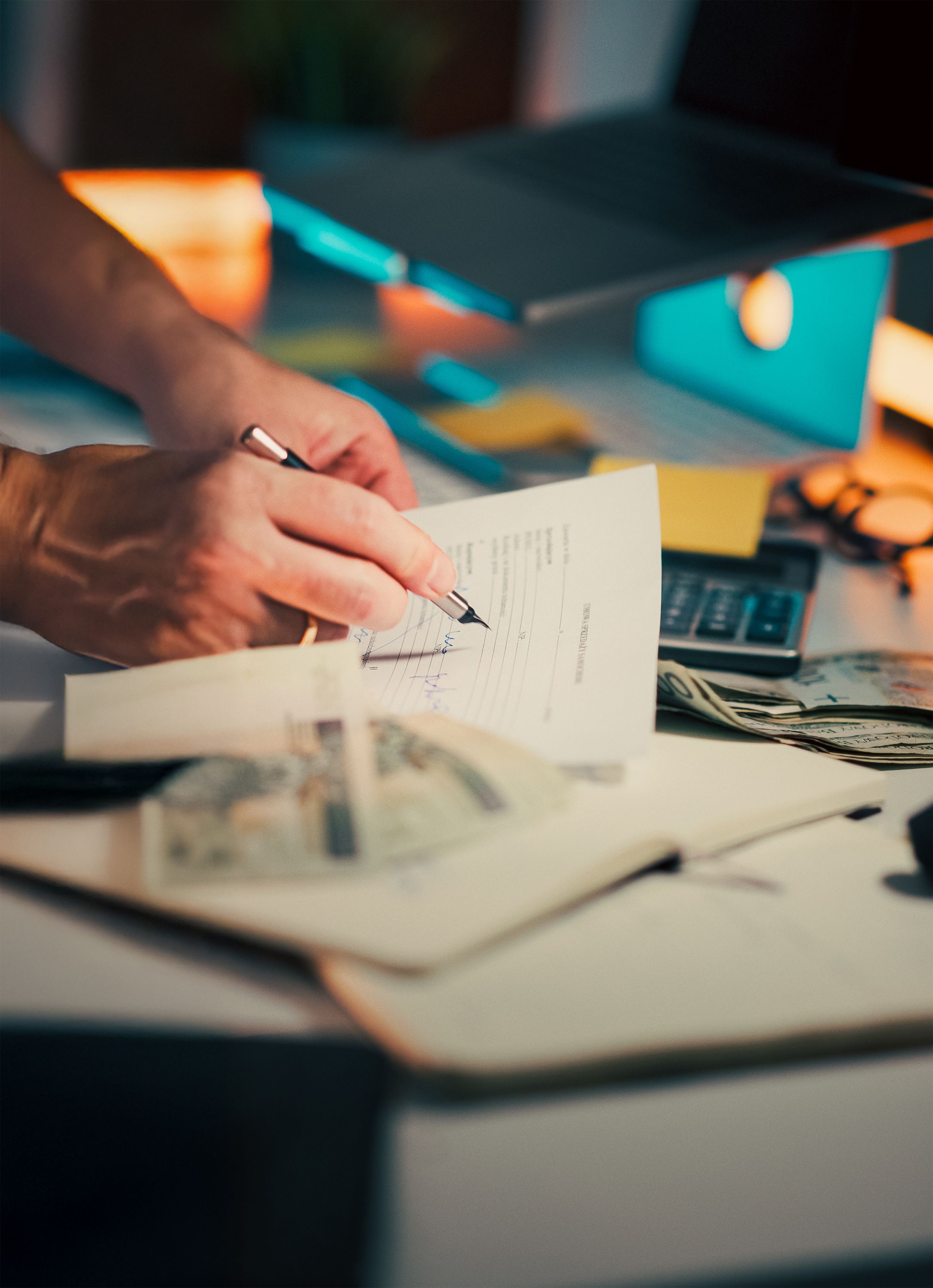 a person pointing at a calculator on a desk