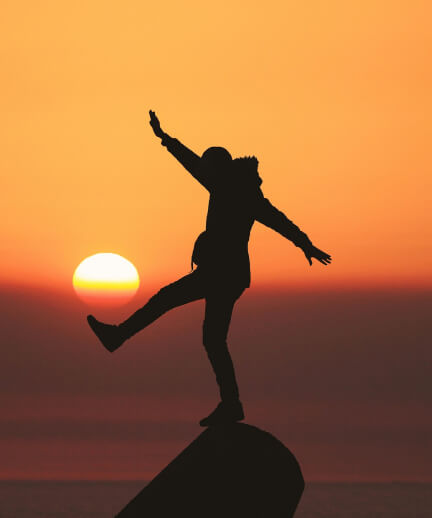 Man standing on a stone, in the background is sunshine