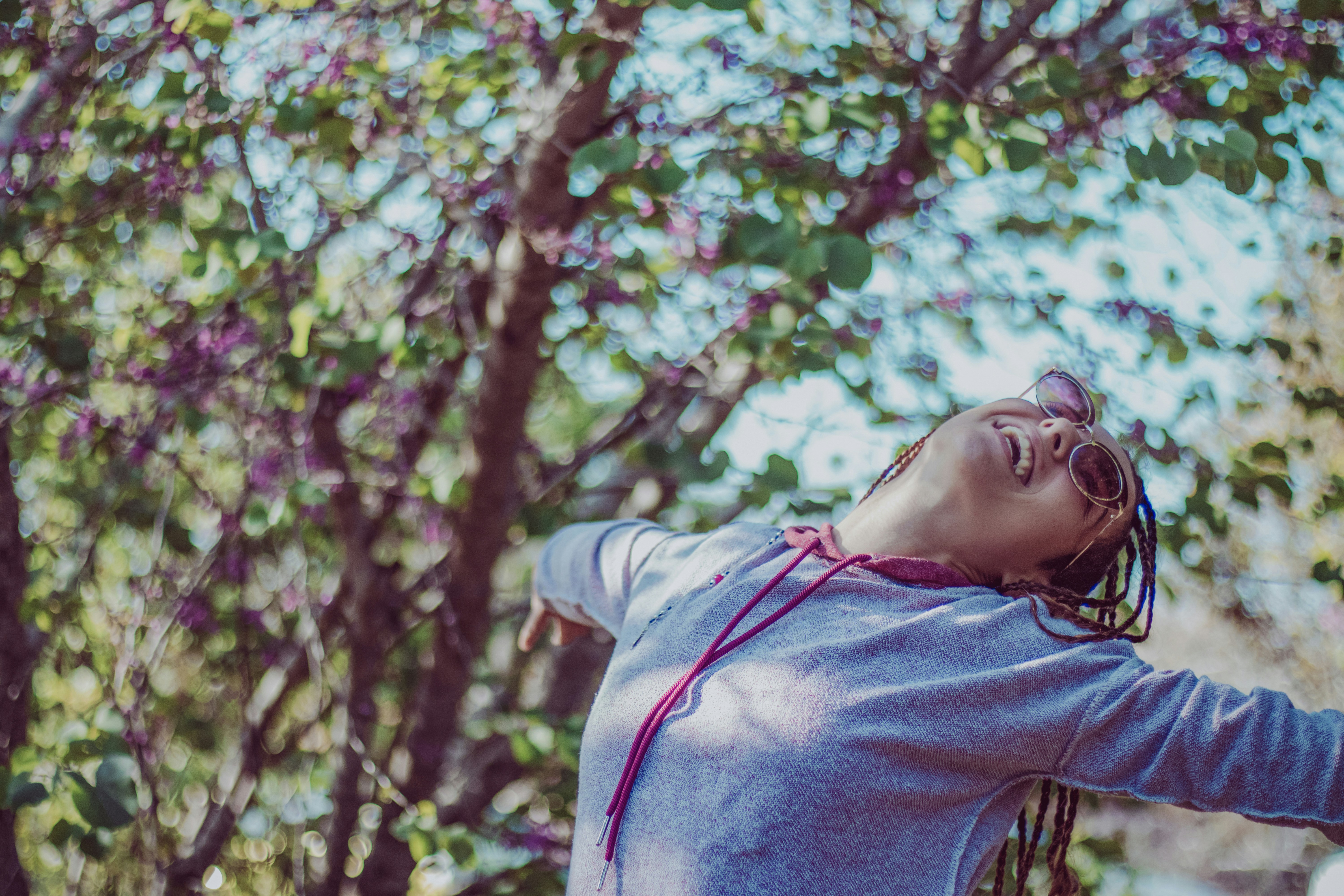 A woman with dreadlocks dancing outside.