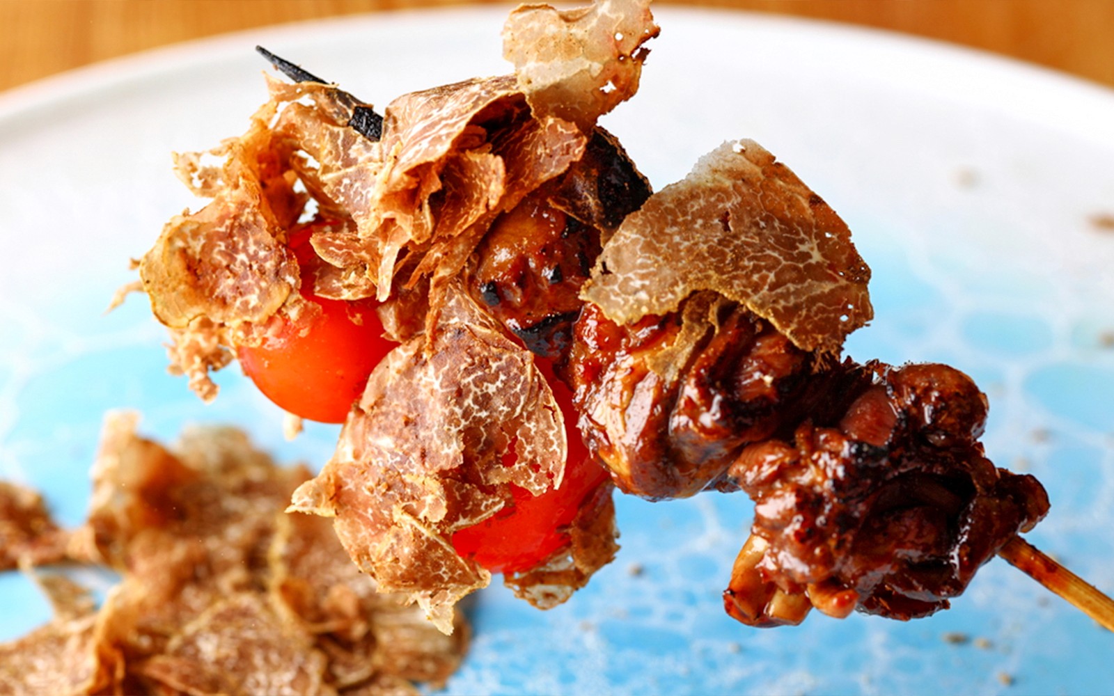 Yakitori chef grilling skewers at Yakitori Tsukiya in Tokyo for 6/9-course meal.