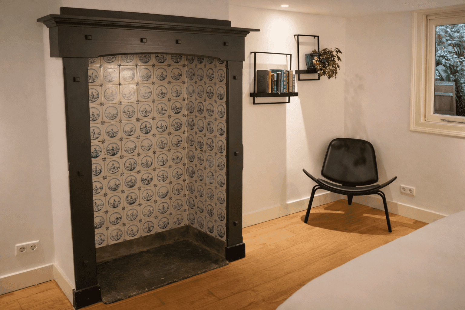 Sfeerfoto van slaapkamer met openhaard en leeshoek