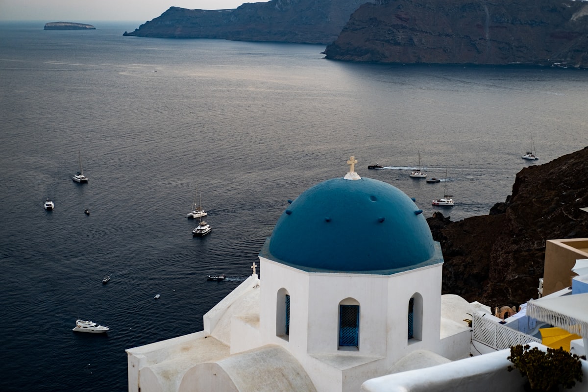 Whitewashed Greek islands Santorini chapel with a blue dome above the Aegean Sea