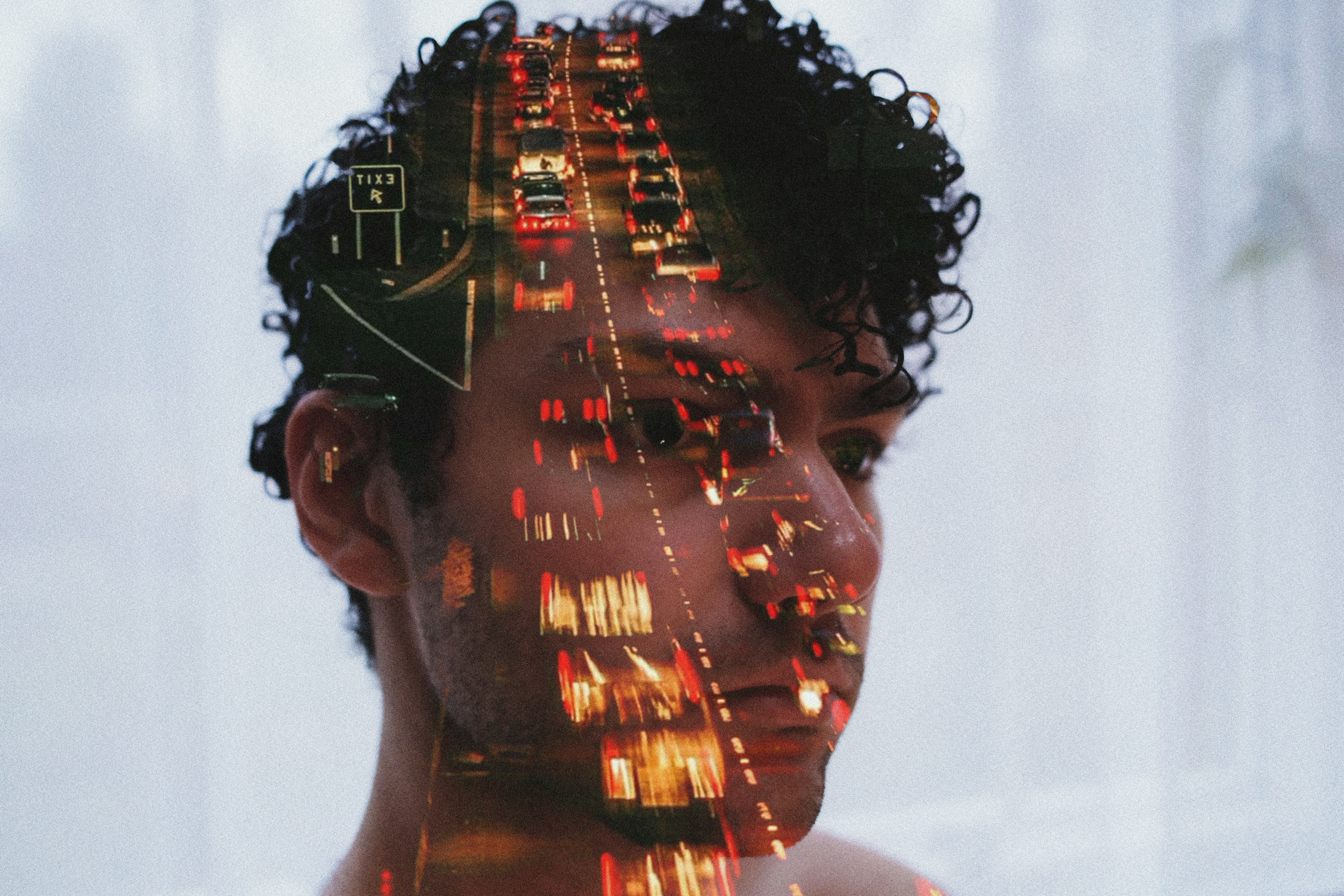 Double exposure of man's face and traffic lights