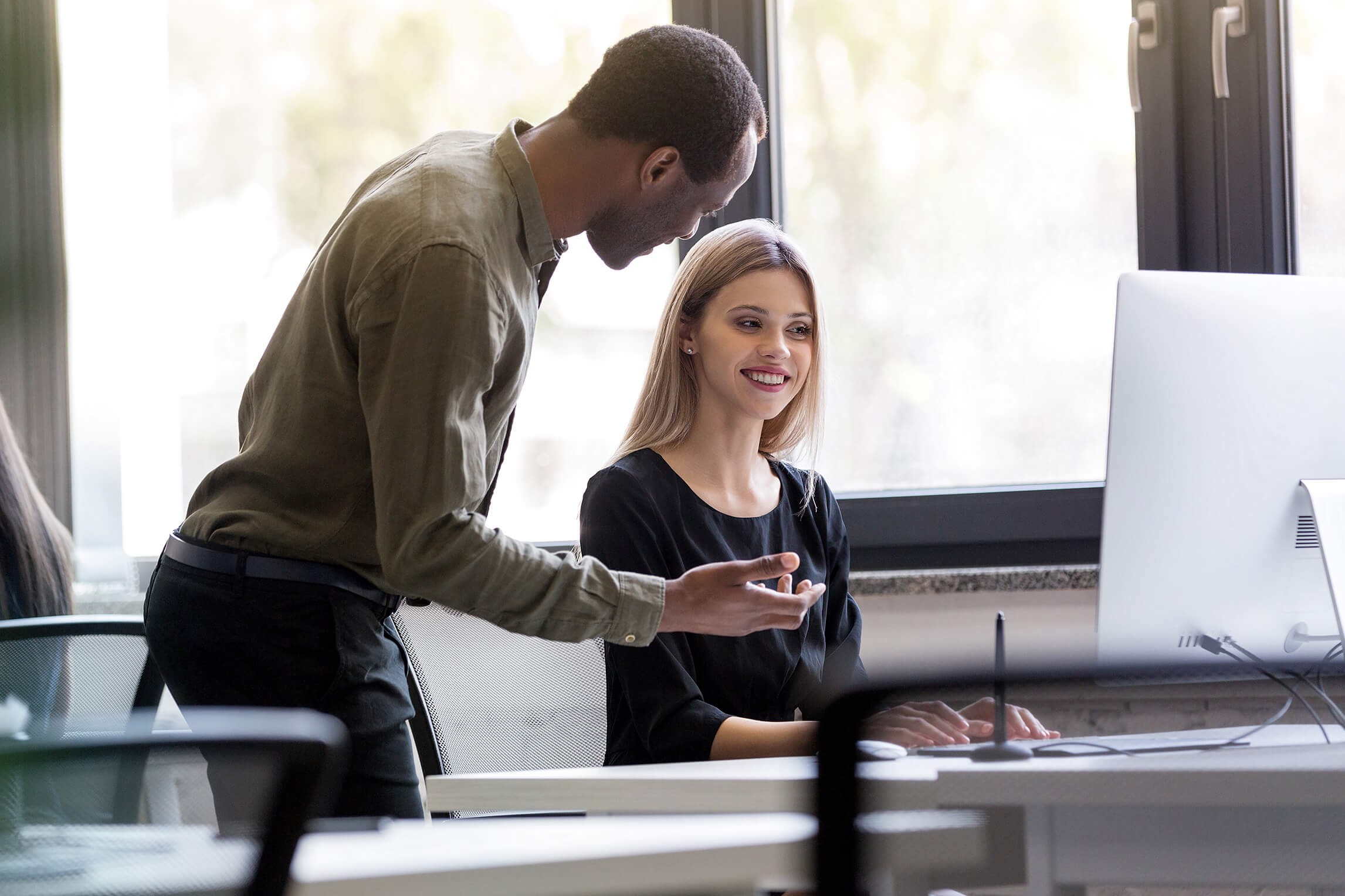  A man and woman collaborating on a computer, sharing ideas and working together to achieve their goals.