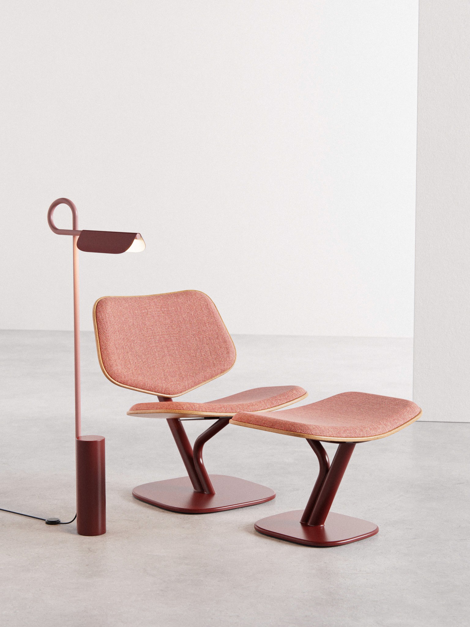 Till Lounge Chair in red fabric with red metal base alongside the Loops Floor Lamp by noknok Studio