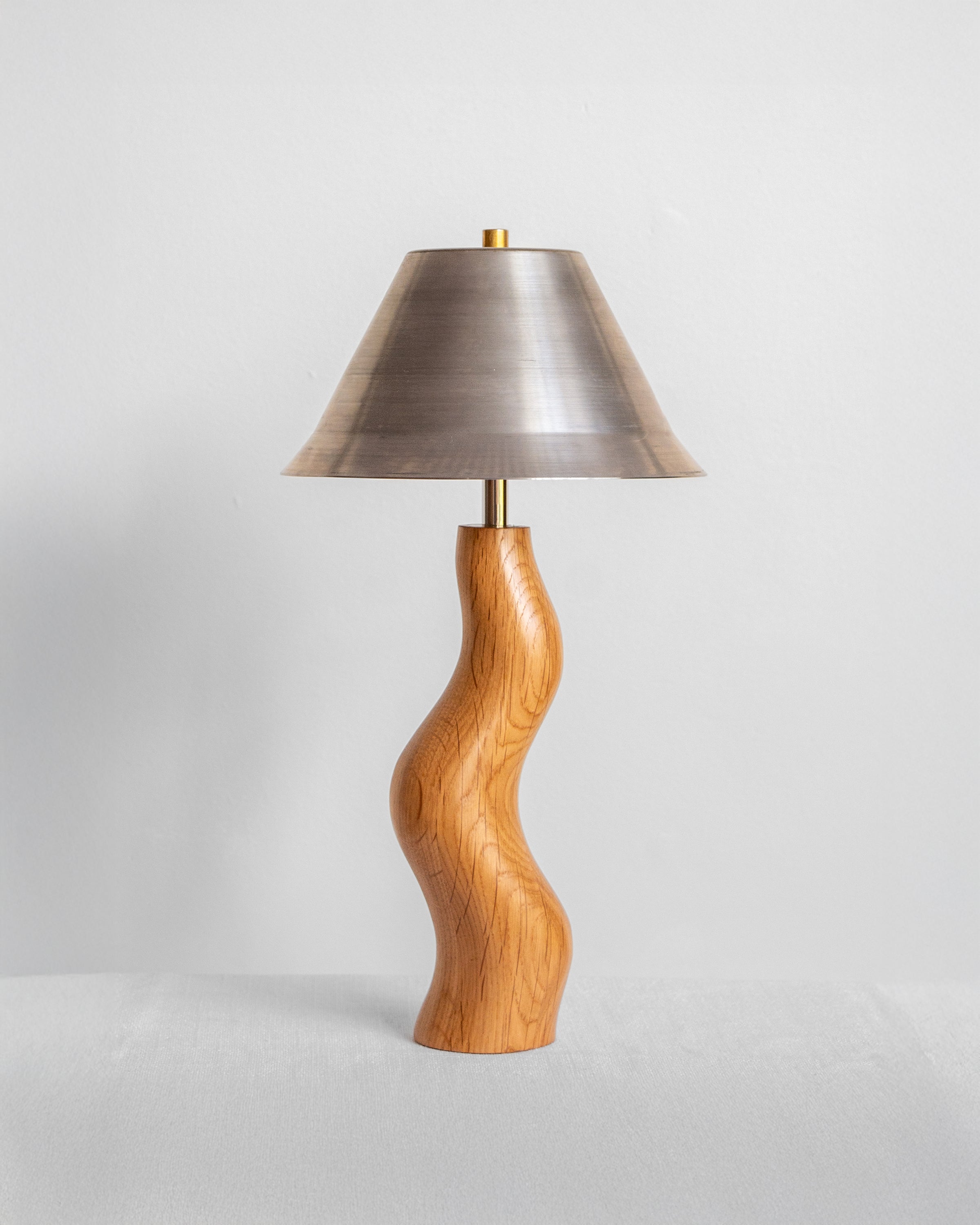 Dancing Desk Lamp with Oak base and Raw Steel shade on a light grey background with UK, EU and US/CA wiring available Wilkinson & Rivera