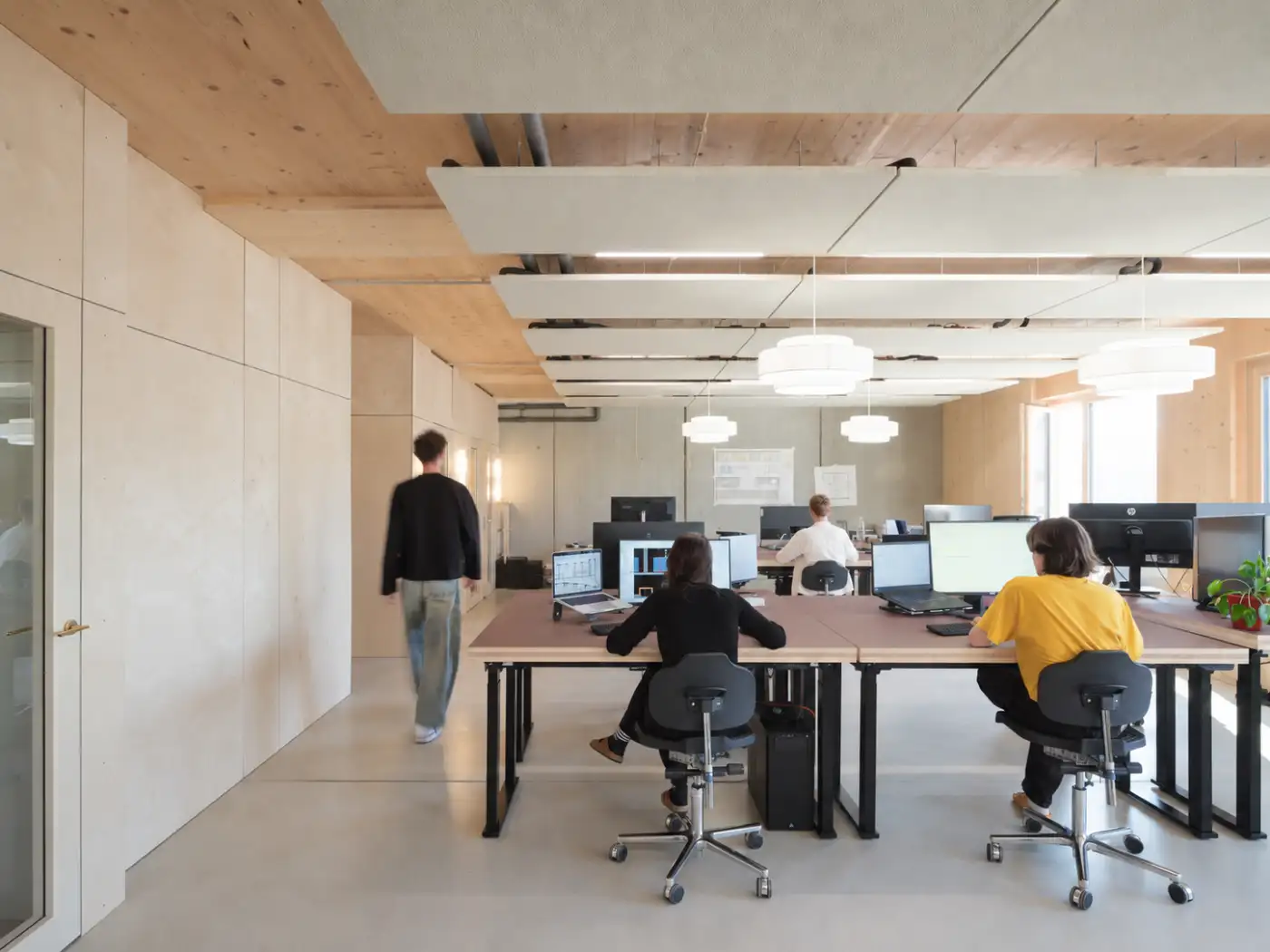 Büro-Loungebereich mit Sofa und abaton Klimasegeln an der Decke vor Panoramafenstern