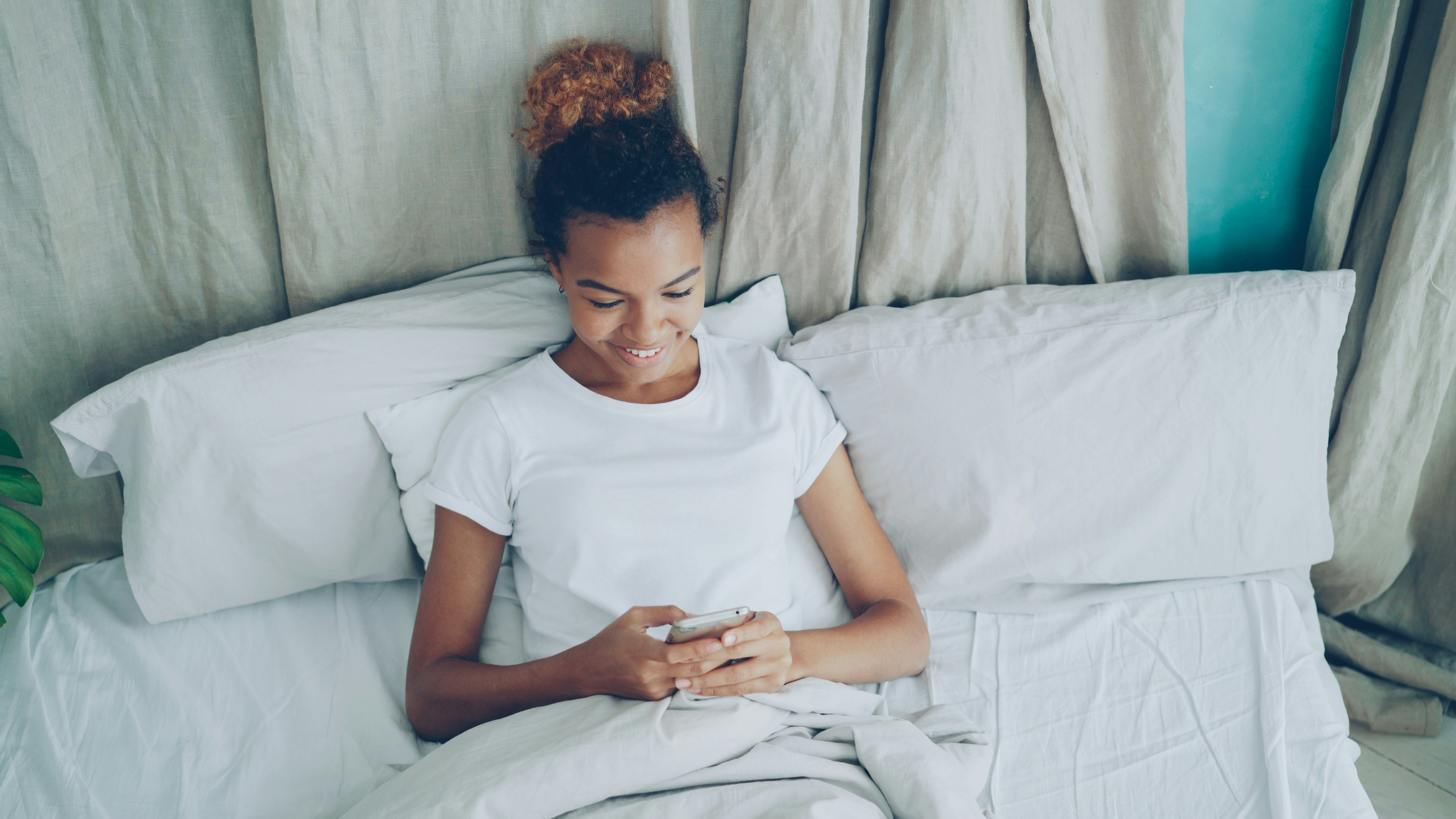 Womean using phone from bed
