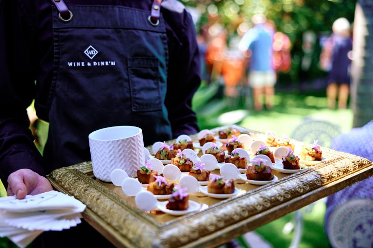 Waiter tray serving pork belly canapes to guests