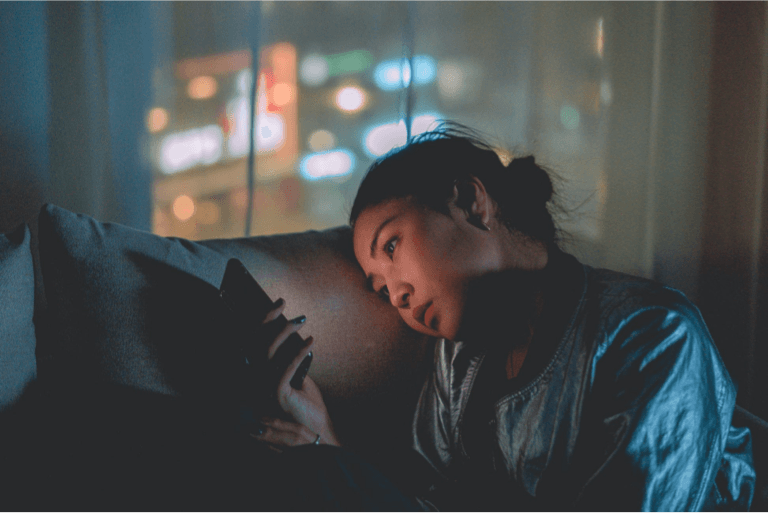 Frau schaut auf ihr Handy.