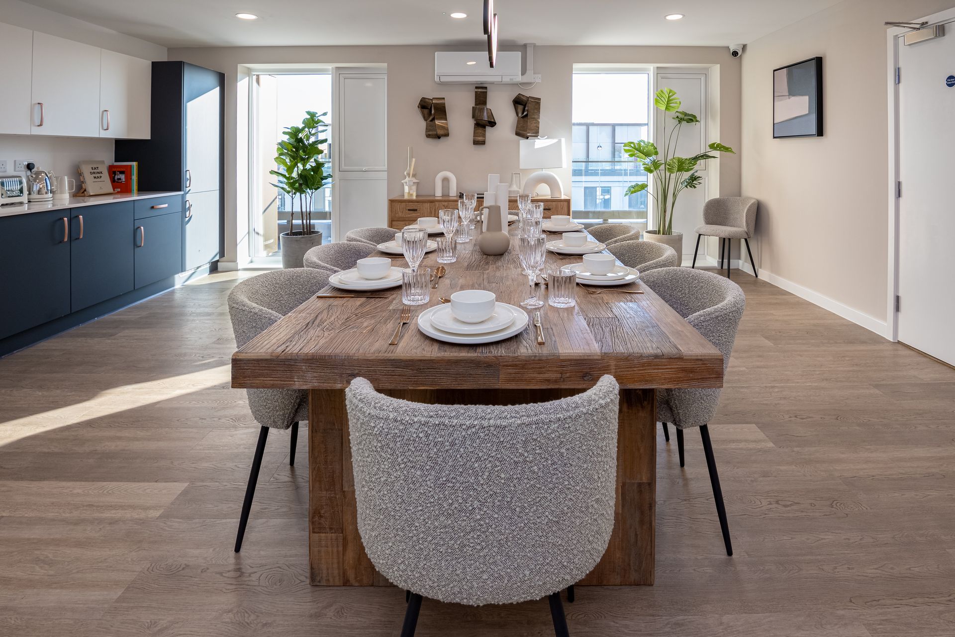 Statement timber dining table stylishly dressed in residents' kitchen and dining area designed by White Circle in Surrey BTR project