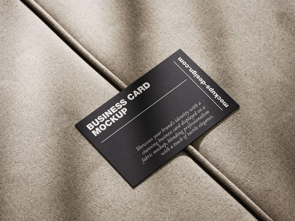 A sleek black business card placed diagonally on a textured beige fabric surface, creating a minimalist and professional look with sharp contrasts and soft lighting.