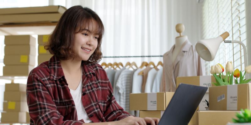 Small business owner looking through her laptop.