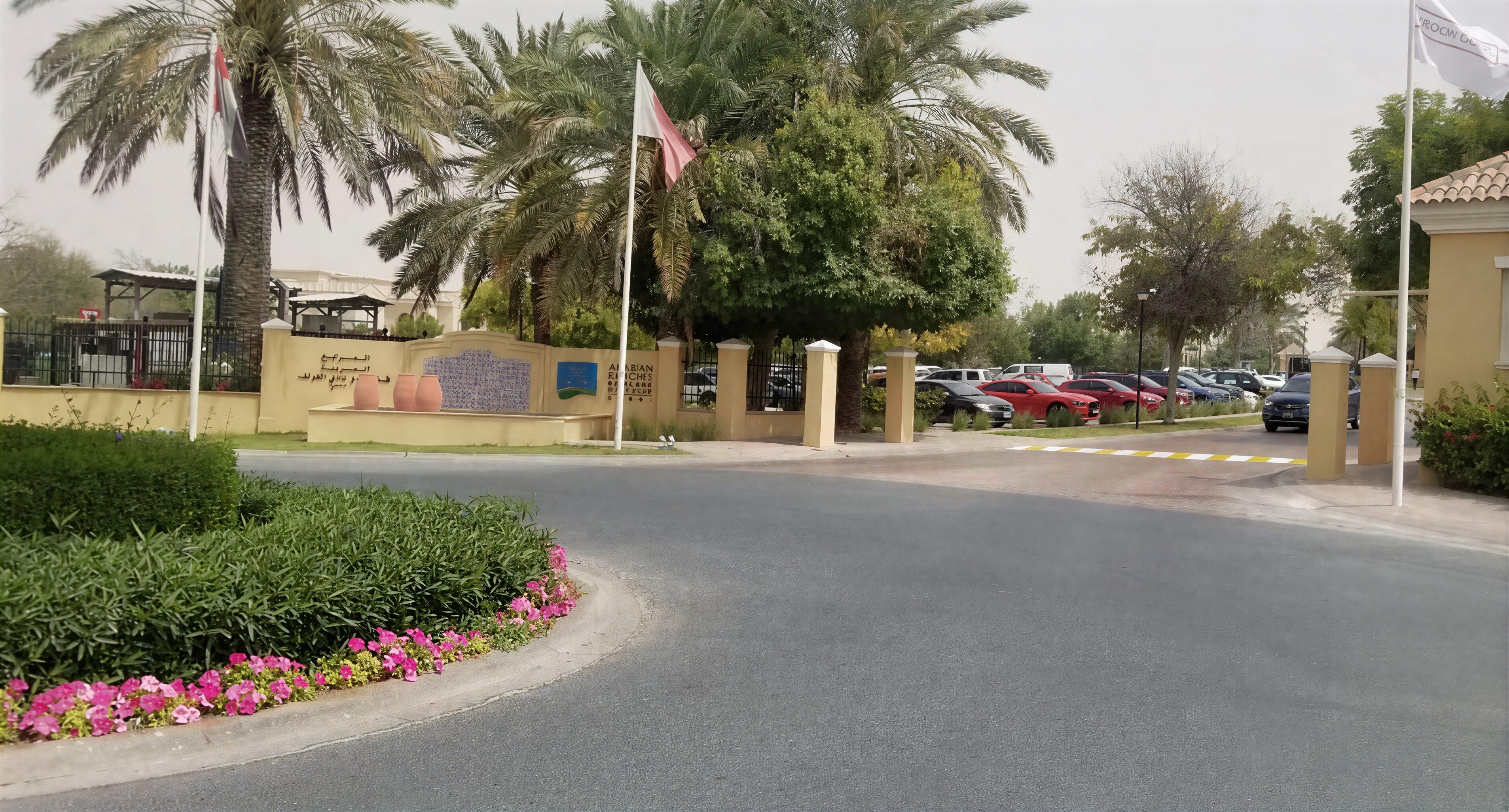 A view of a parking lot with vehicles near the Arabian Ranches shopping center.