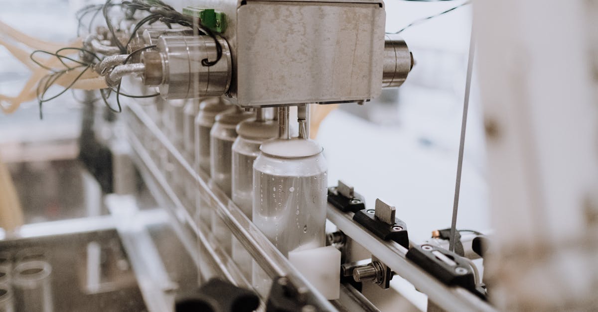 Close-up of an automated can filling machine in a beverage production line.
