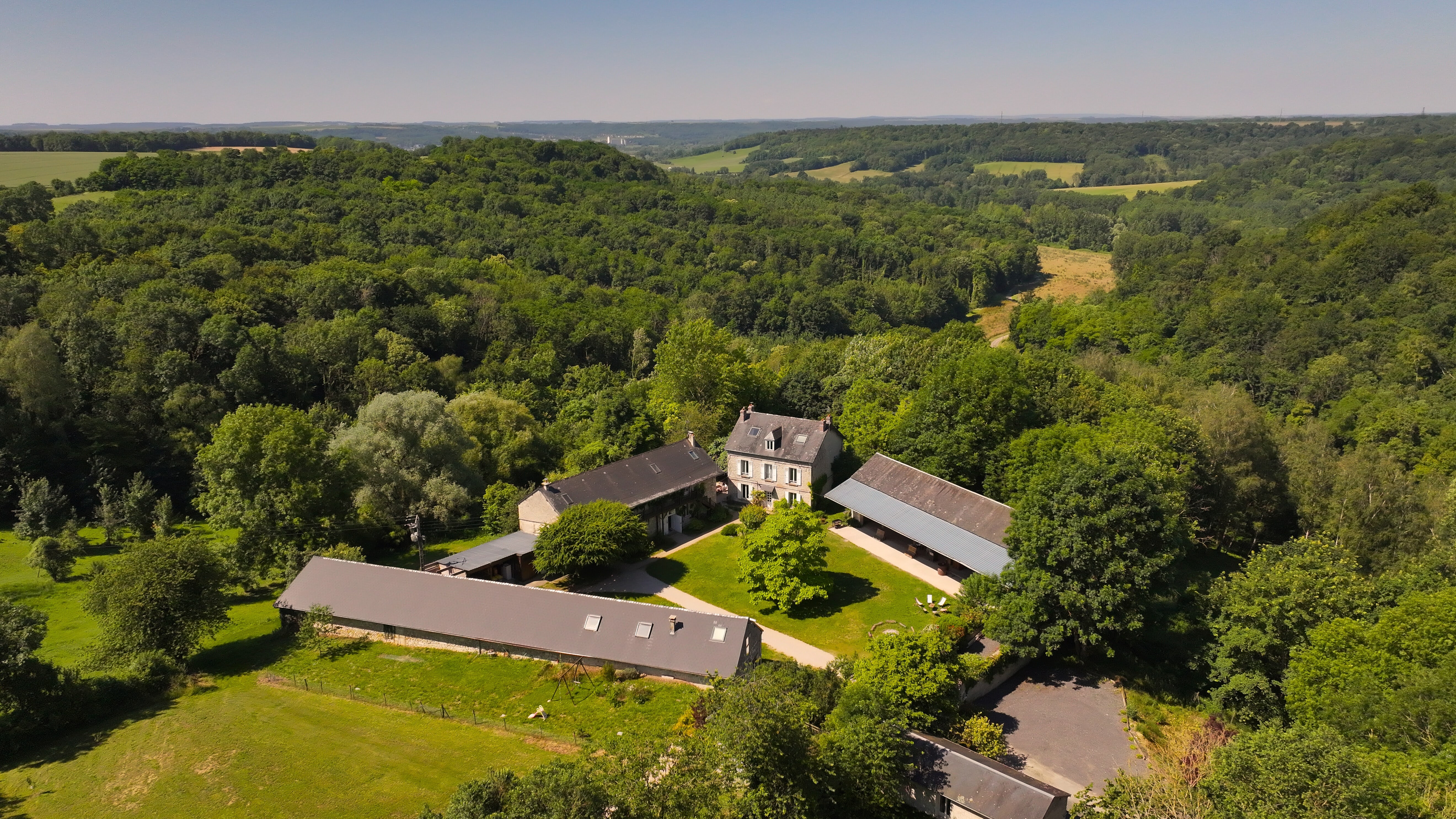 Vue au drone du domaine de Verdonne, entouré par des forêts à perte de vue.
