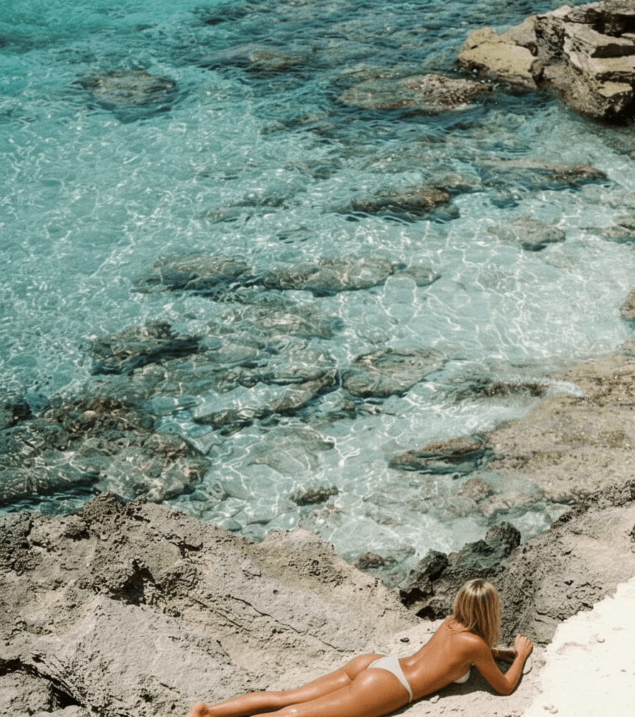Man sitting in a dimly lit room, wearing a beige shirt and looking contemplative.