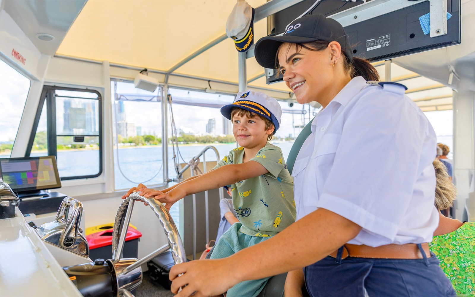 Child steering cruise ship with captain's guidance.