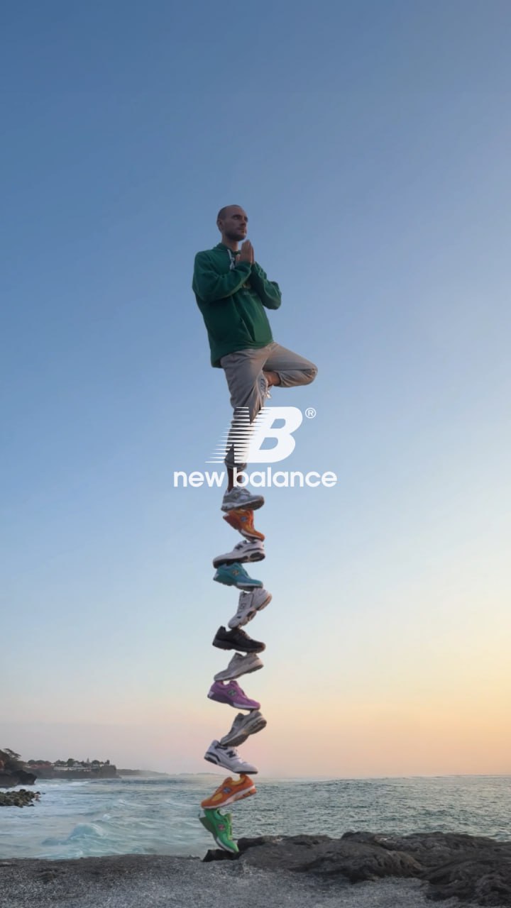 A man in a yoga pose balances on a tall, precarious stack of New Balance shoes, a clever CGI 3D visual.