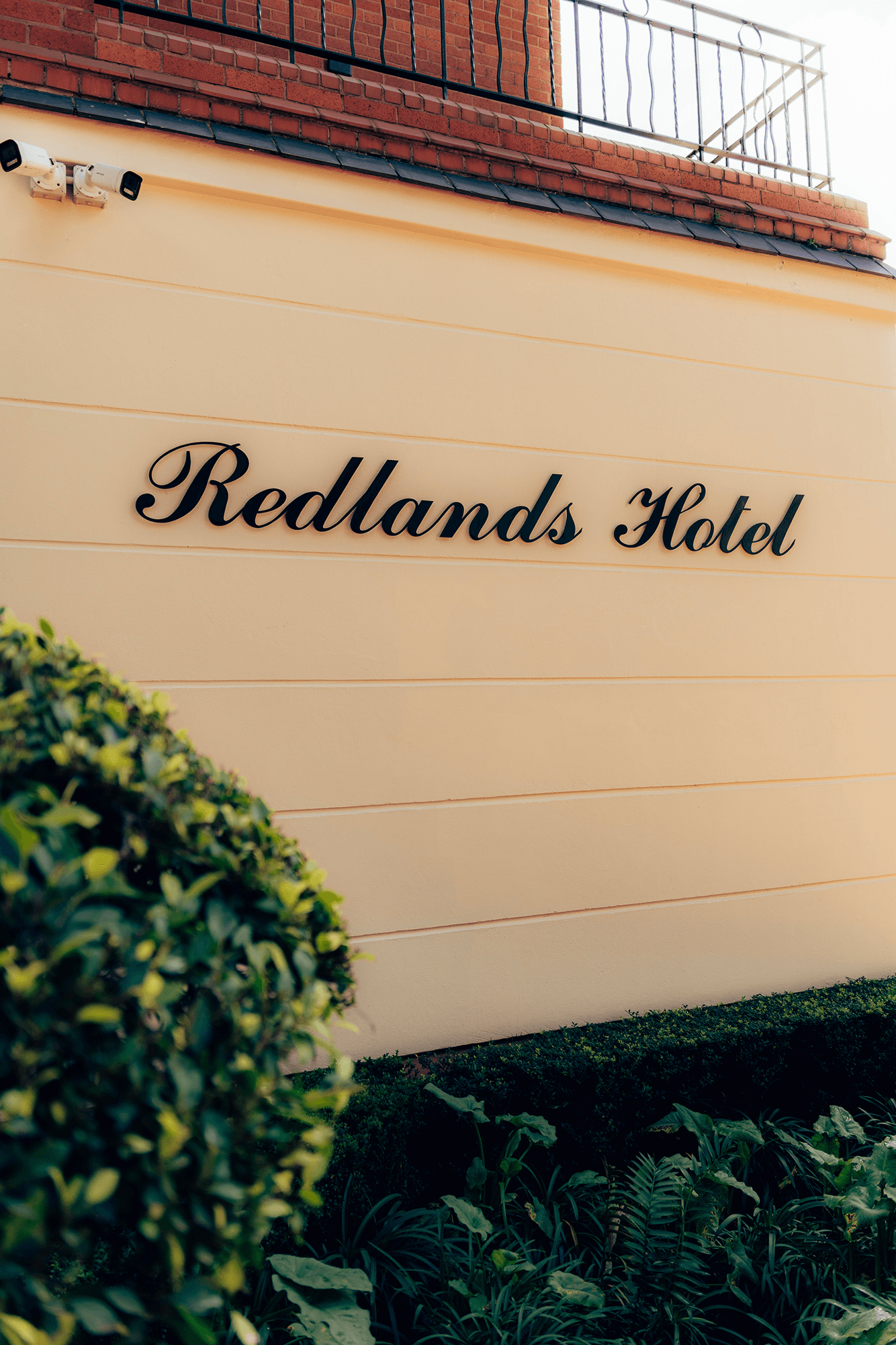 Sparkling outdoor swimming pool surrounded by lush gardens at Redlands Hotel.