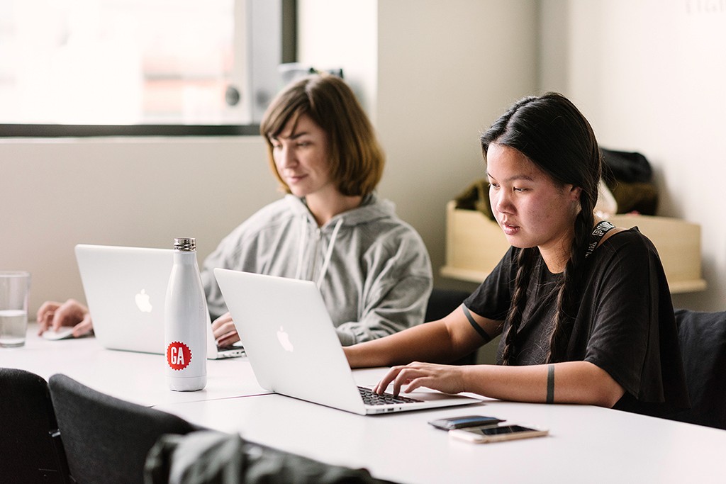 A designer reviewing clustered ideas on a board, moving from complexity toward clarity.