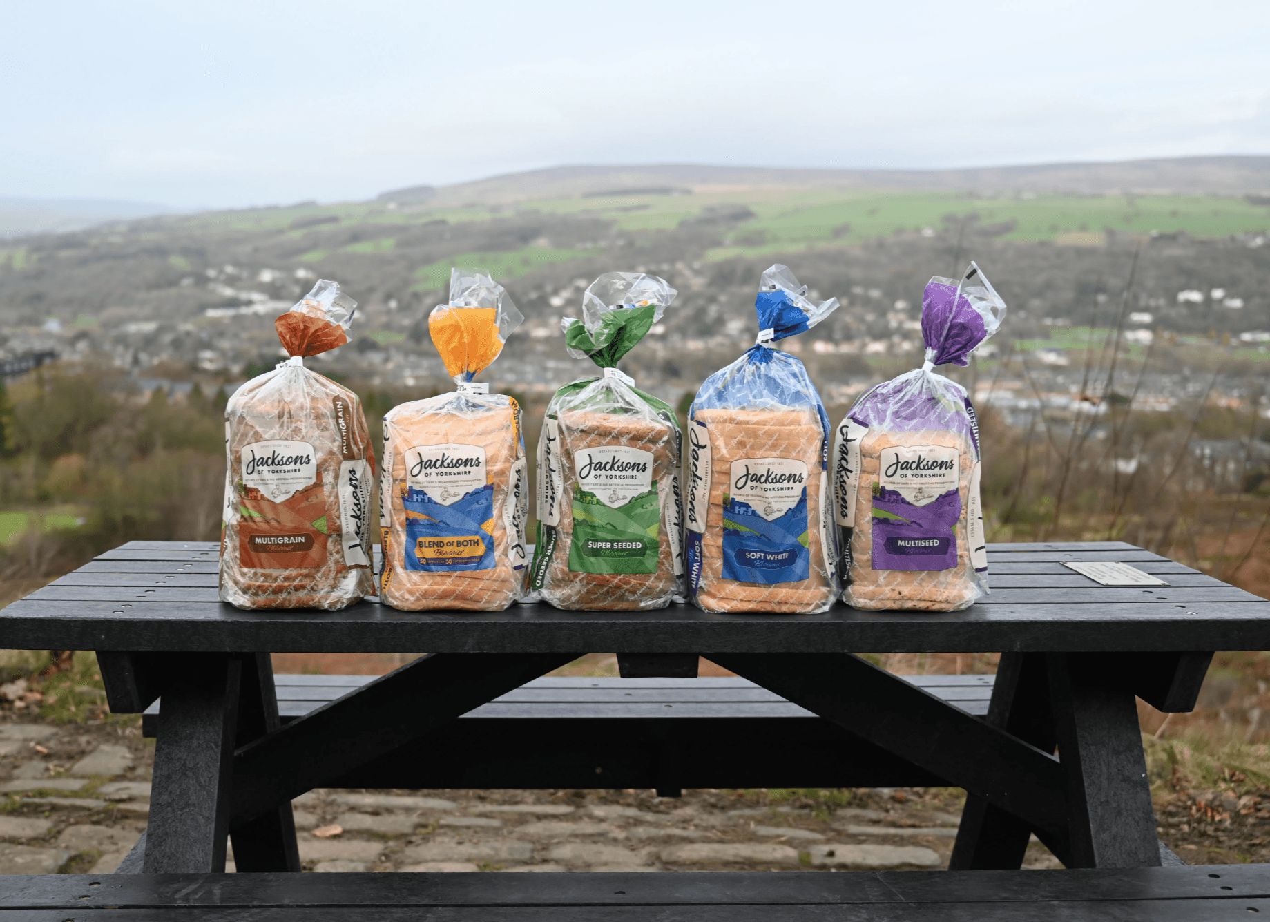 Five loaves of bread on a picnic bench overlooking the Yorkshire Dales