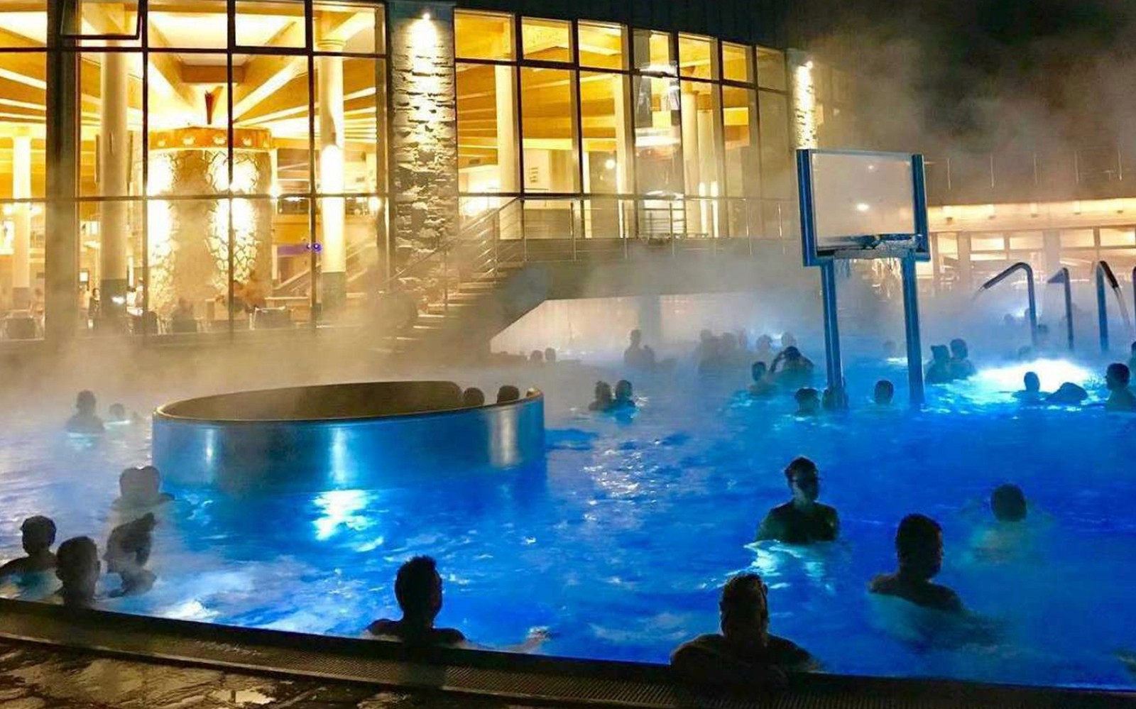 Gestir njóta upplýstra lauga í Chocholow Thermal Baths Saunarium á kvöldin.