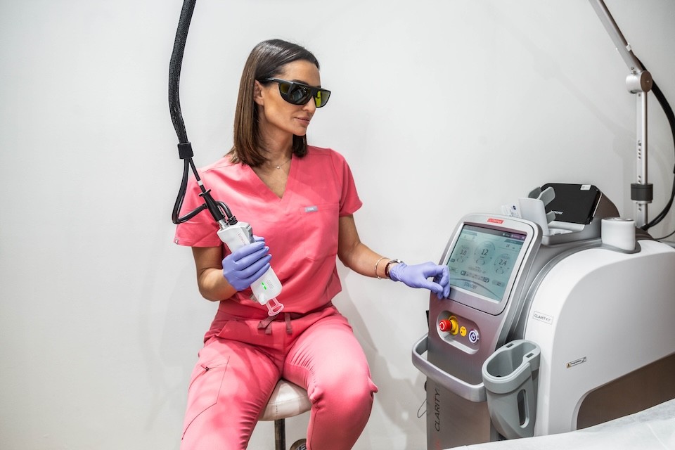 Technician adjusting settings on cosmetic laser machine