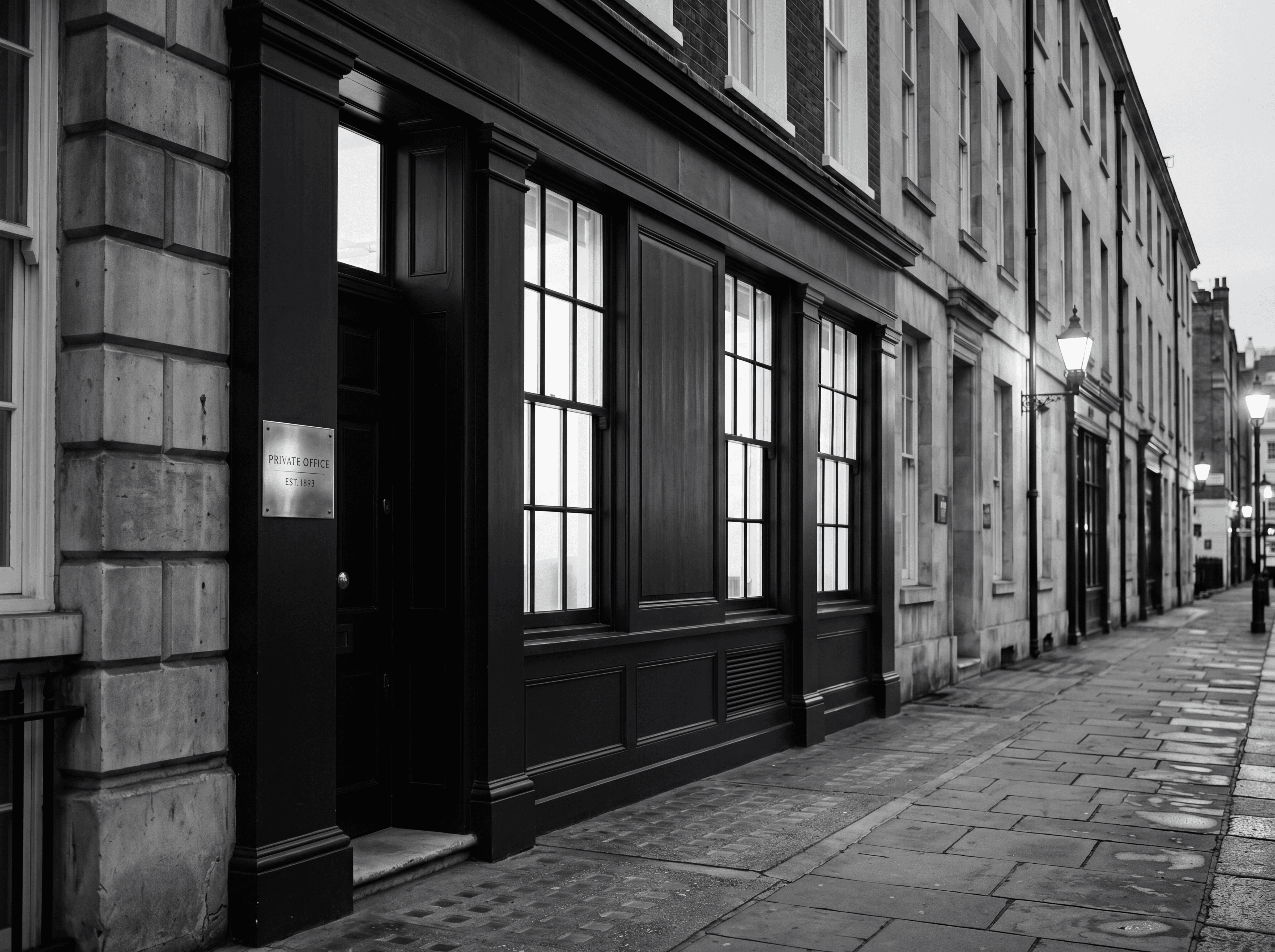 A discreet Mayfair commercial frontage at dusk in black and white, representing buyer and tenant commercial search representation for family offices and private investors in London.