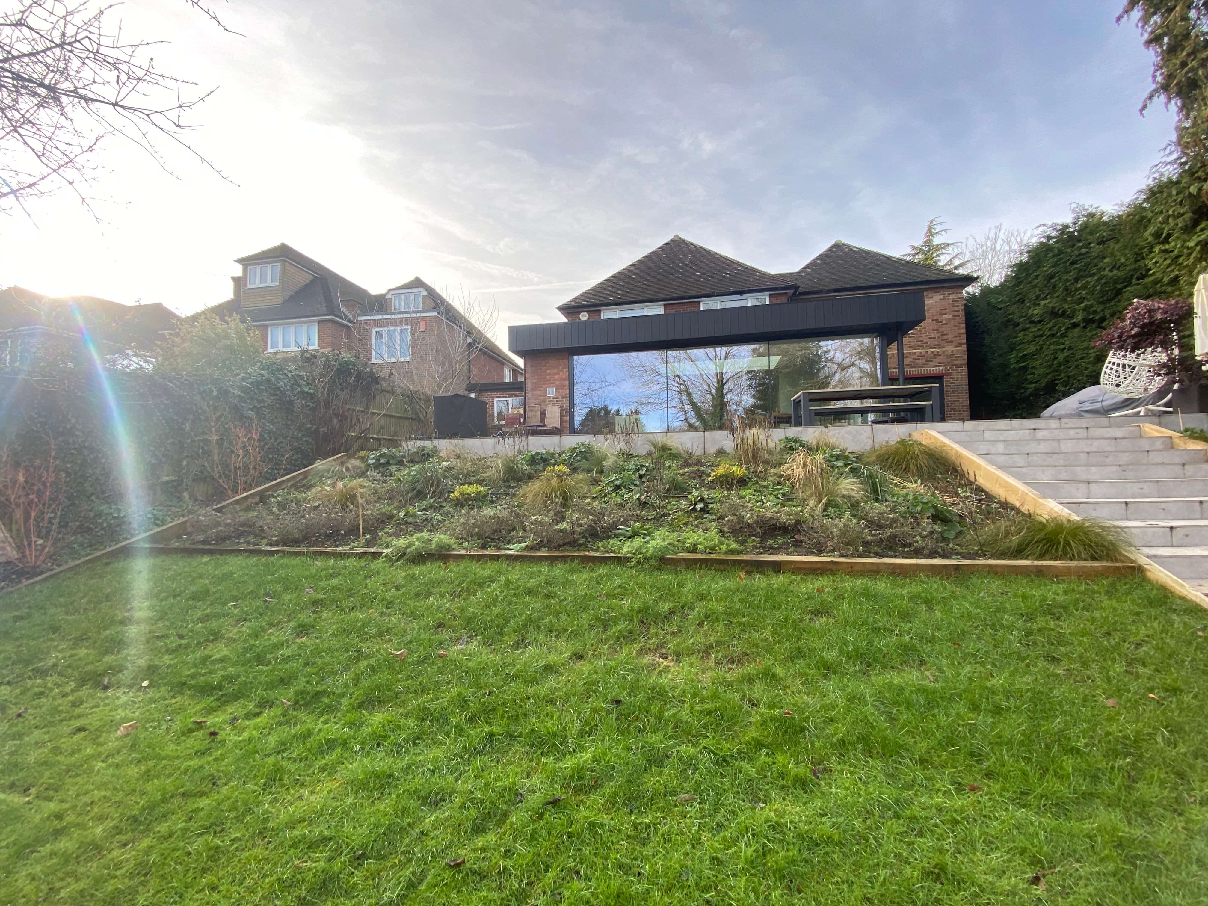 Modern porcelain tiered garden steps and sloped lawn installation in High Wycombe."