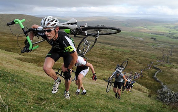 People carrying bikes on their shoulders