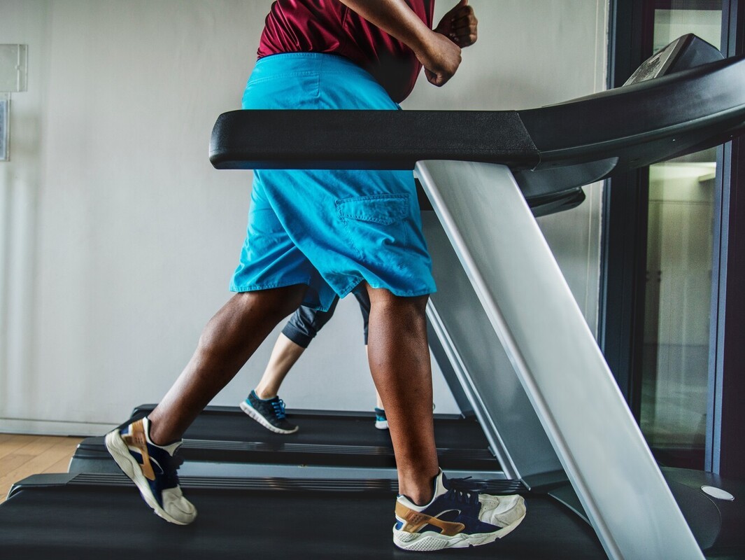 plus-sized man losing weight on treadmill at the gym by walking at a brisk pace