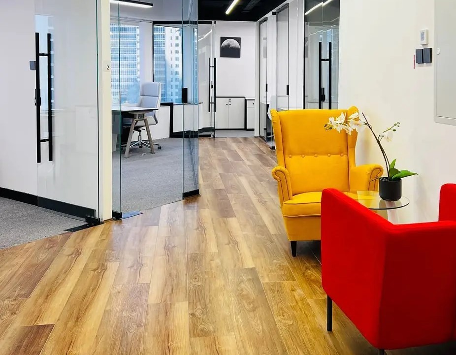 Stylish office lounge area with vibrant seating and wood flooring in a luxury Dubai commercial property.