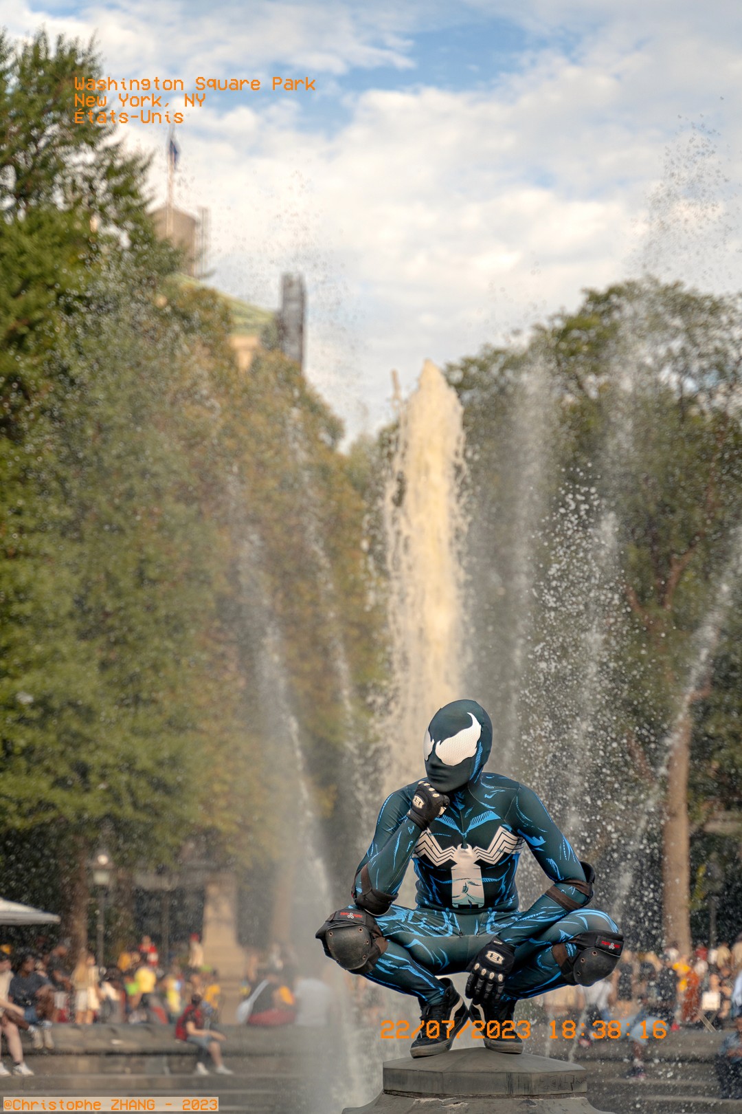  Personnage en costume de super-héros posant devant une fontaine à Washington Square Park.