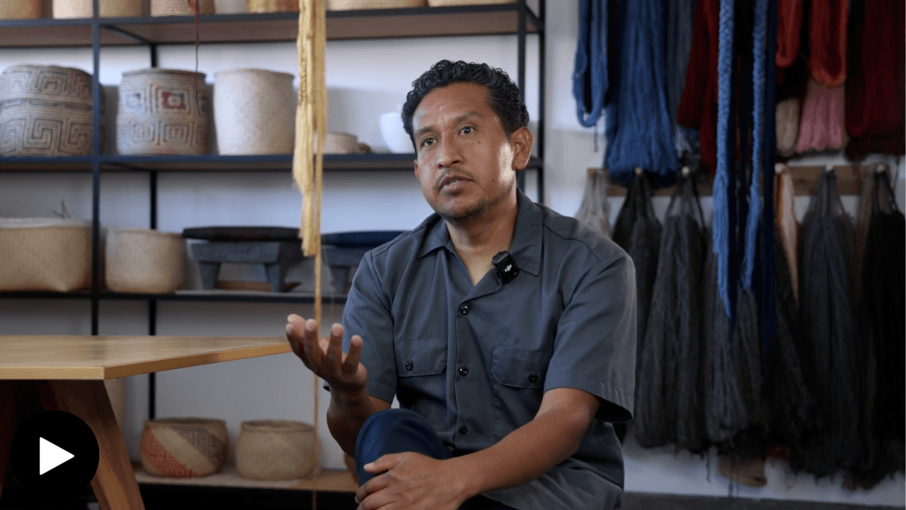 Porfirio Giutierrez in his studio, with ceramics and yarn behind him.