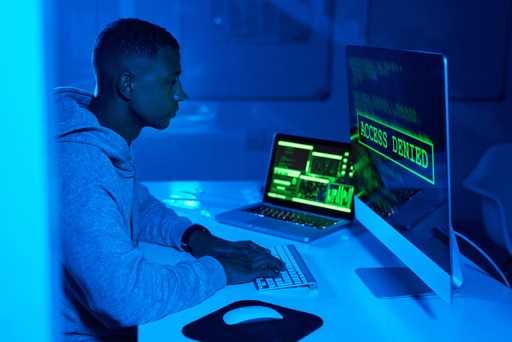 man sitting in front of computer hacking