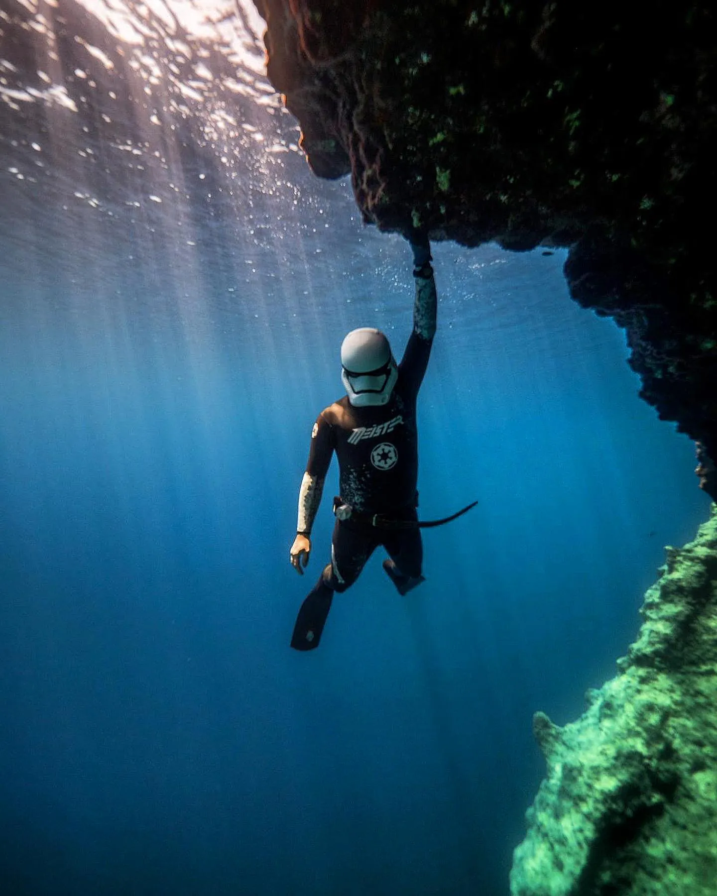 freediver meister holding on a rock with star wars helmet