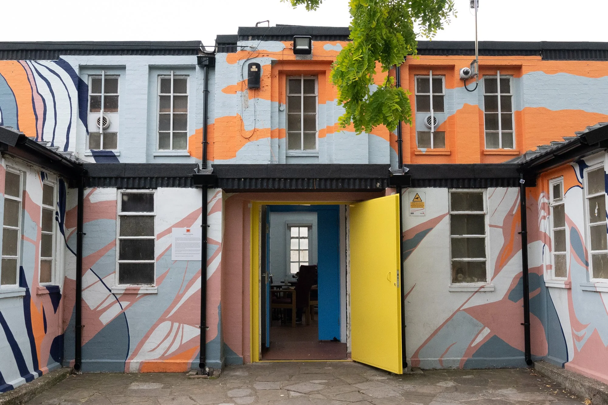 The front of the APAP building, with a large vivid and bright pattern on the walls