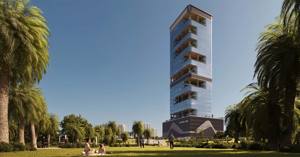 A tall building featuring a large central tower, set within a park, representing Capital One.