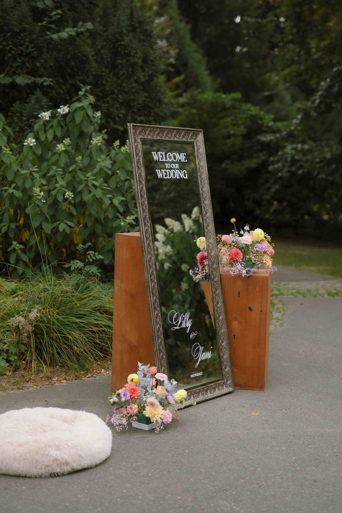 Hochzeitsdekoration mit Spiegel, Blumen und Willkommensbotschaft